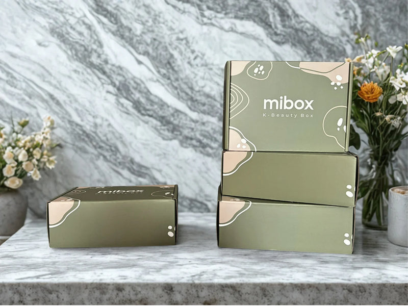 Кутии за корейска козметика Mibox на маса с мраморен фон и цветя, K-beauty box